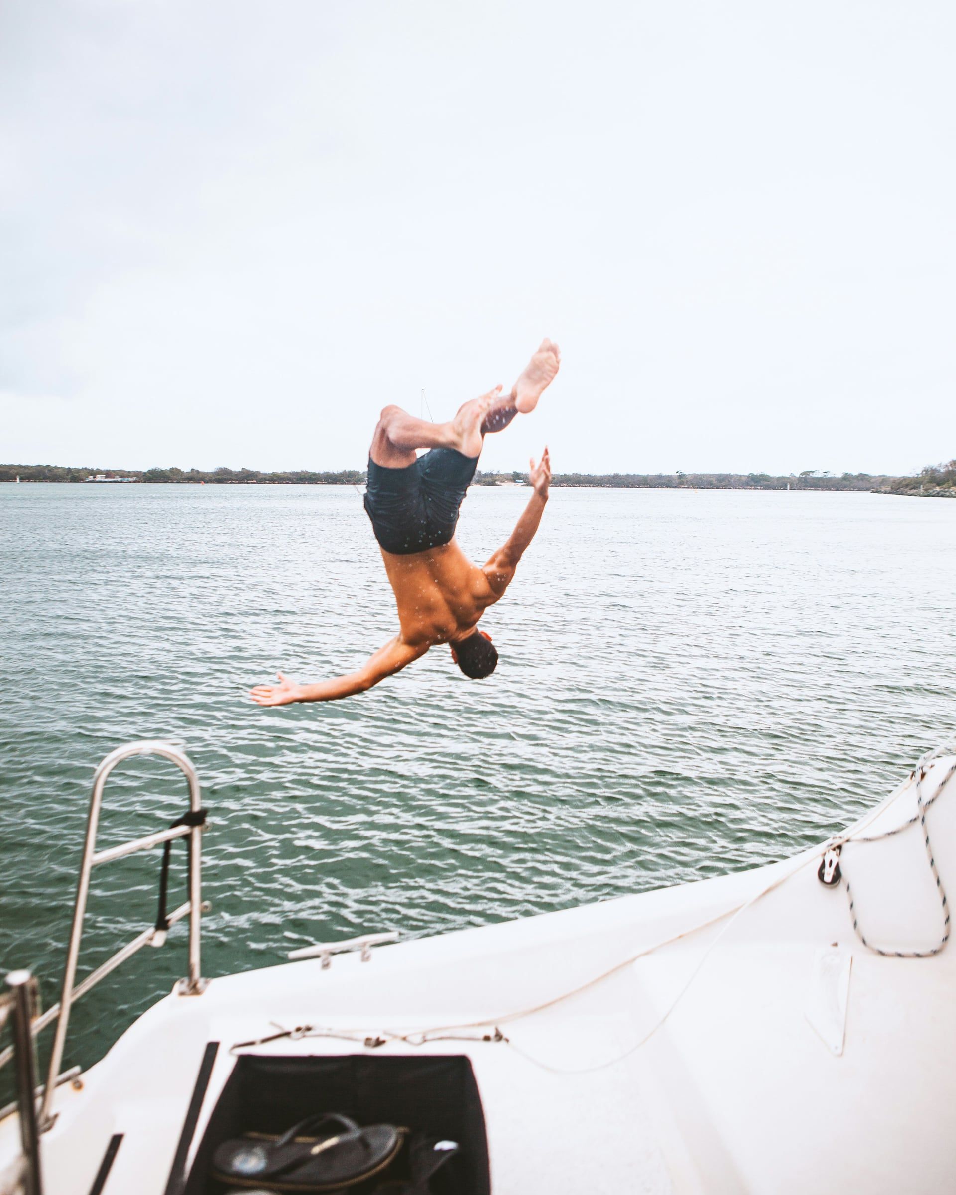 A man diving off a boat into the sea.